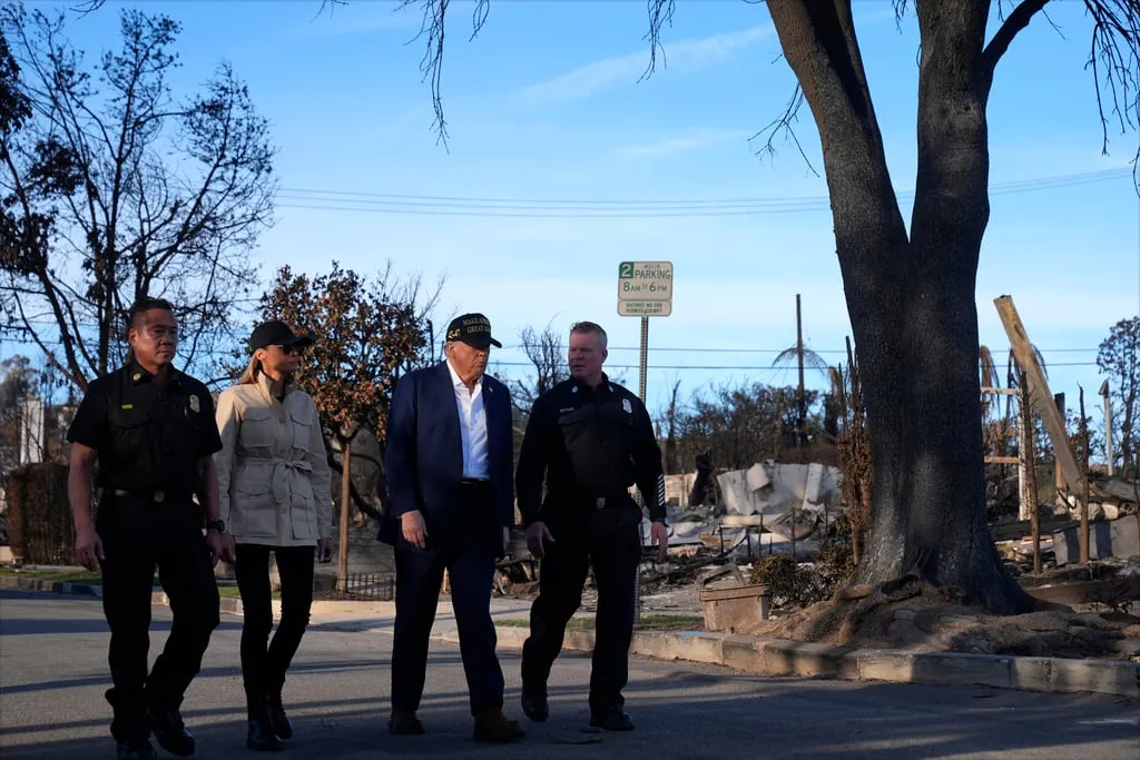 El presidente Donald Trump y la primera dama Melania Trump caminan con Jason Hing, jefe adjunto de los servicios de emergencia del Departamento de Bomberos de Los Ángeles, izquierda, y el capitán Jeff Brown, jefe de la Estación 69, mientras recorren el vecindario de Pacific Palisades afectado por los recientes incendios forestales en Los Ángeles, viernes 24 de enero de 2025. (Foto AP/Mark Schiefelbein)