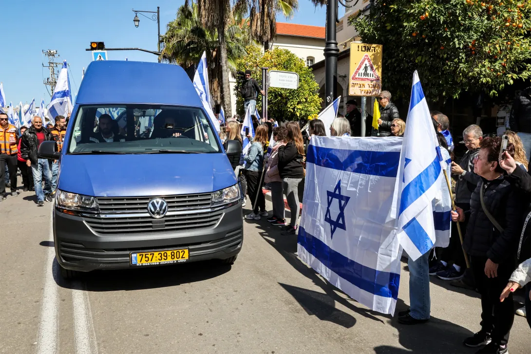 Camioneta lleva el cuerpo de uno de los israelíes secuestrado y asesinado por Hamás. Fue recibido en medio de homenajes.