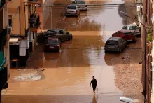 Un hombre cargando agua camina por calles inundadas en Valencia, España, el miércoles 30 de octubre de 2024. (Foto AP/Alberto Saiz)