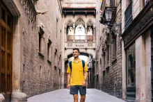 Joven sonriente y feliz caminando por las calles del Barrio Gótico de Barcelona, ​​España