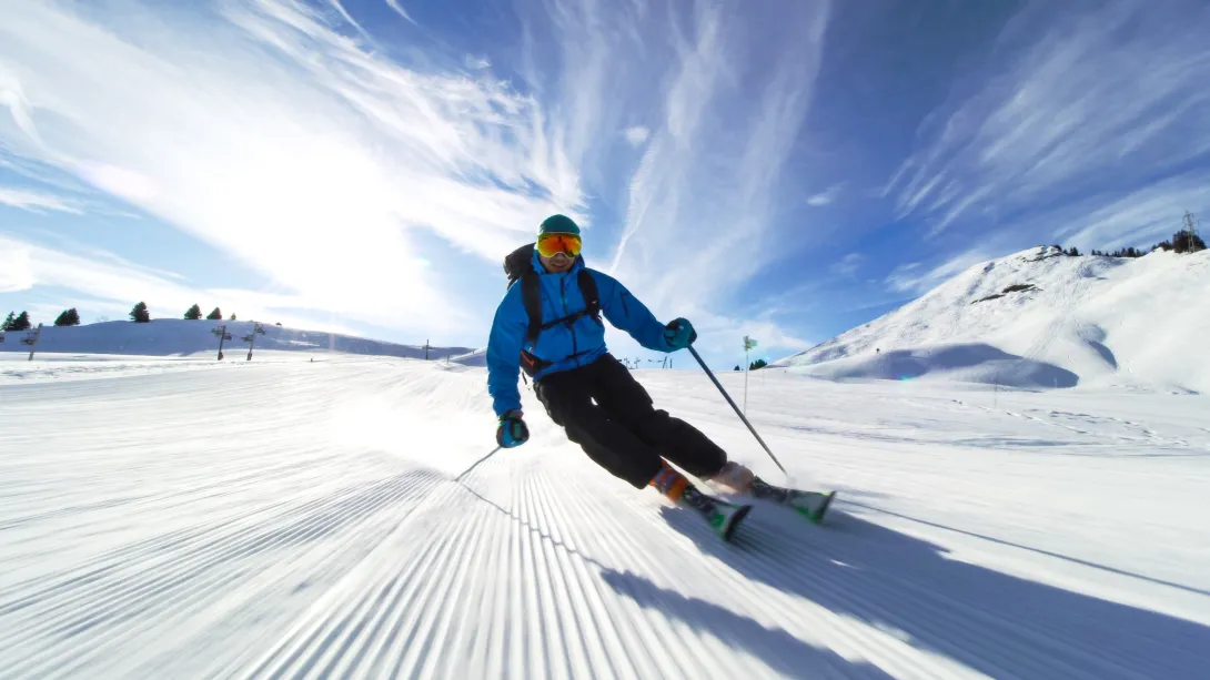 Esquiador profesional esquiando en pistas de los Alpes suizos hacia la cámara.