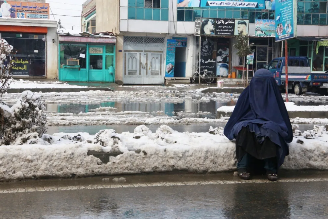 Una mujer sentada en un camino nevado después de una nevada en Kabul, Afganistán, el 23 de enero de 2022. (Foto de Bilal Guler/Agencia Anadolu a través de Getty Images)