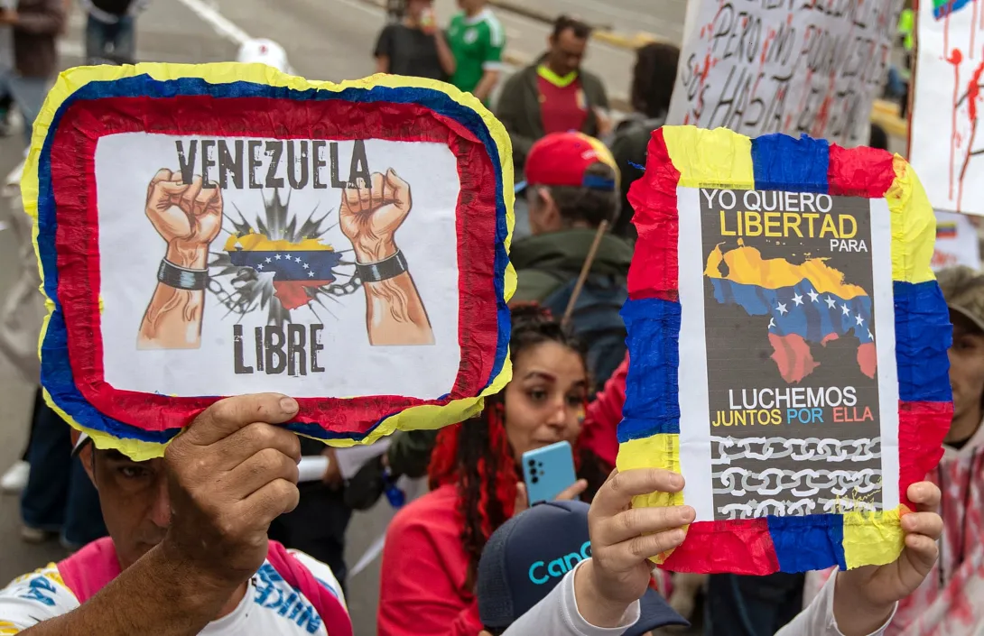 Manifestantes sostienen carteles contra el gobierno del presidente venezolano Nicolás Maduro durante una manifestación en Bogotá el 1 de diciembre de 2024