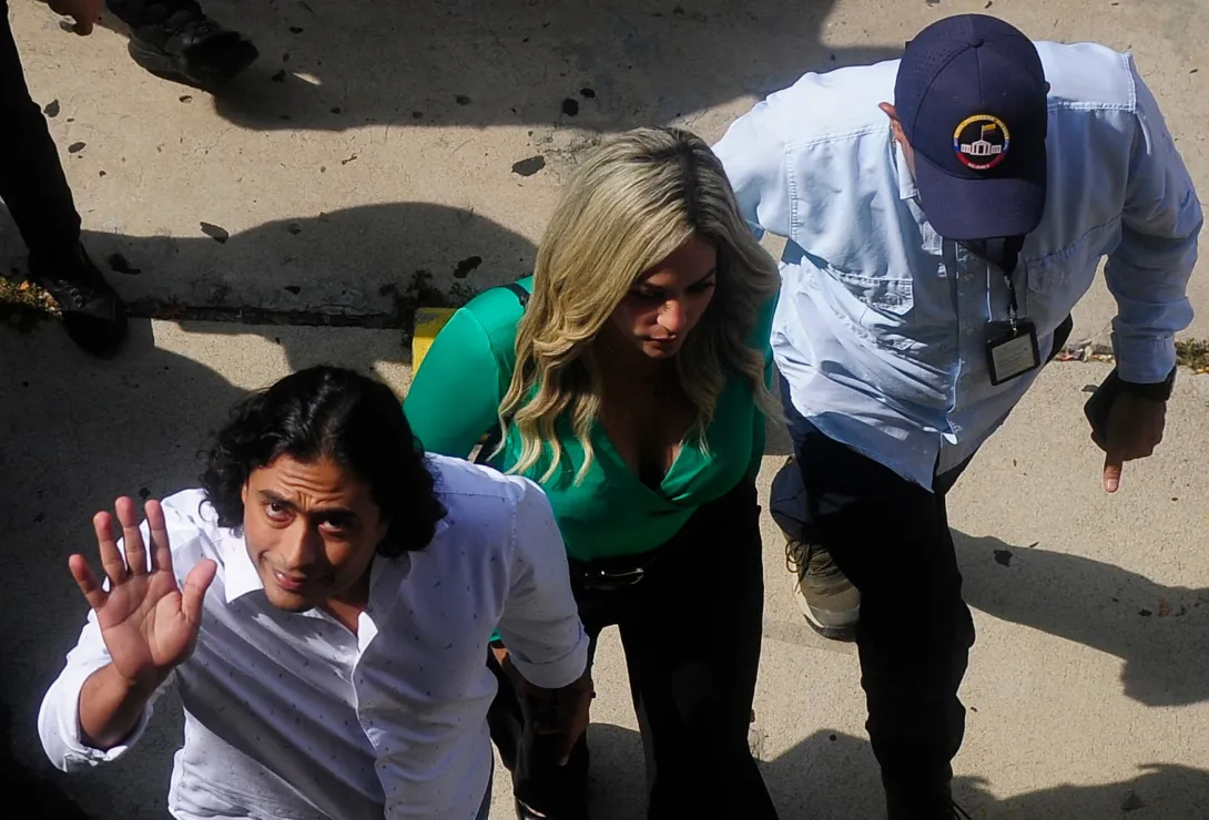 Nicolas Petro (L), son of Colombian President Gustavo Petro, accompanied by his girlfriend Laura Ojeda, arrives for a hearing at the Supreme Court of Justice in Barranquilla, Colombia, September 10, 2024. Nicolas Petro, currently on parole, was arrested on July 29, 2023, on charges of money laundering and illicit enrichment in a scandal linked to his father's election campaign. (Photo by Jesus RICO / AFP)